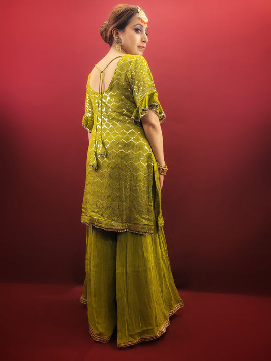 Embrace elegance with a mehendi green sharara set, featuring a dazzling sequins work and a beads & zari embellished neckline, crafted from luxurious chinnon fabric for a quintessential Indian ethnic wear ensemble.