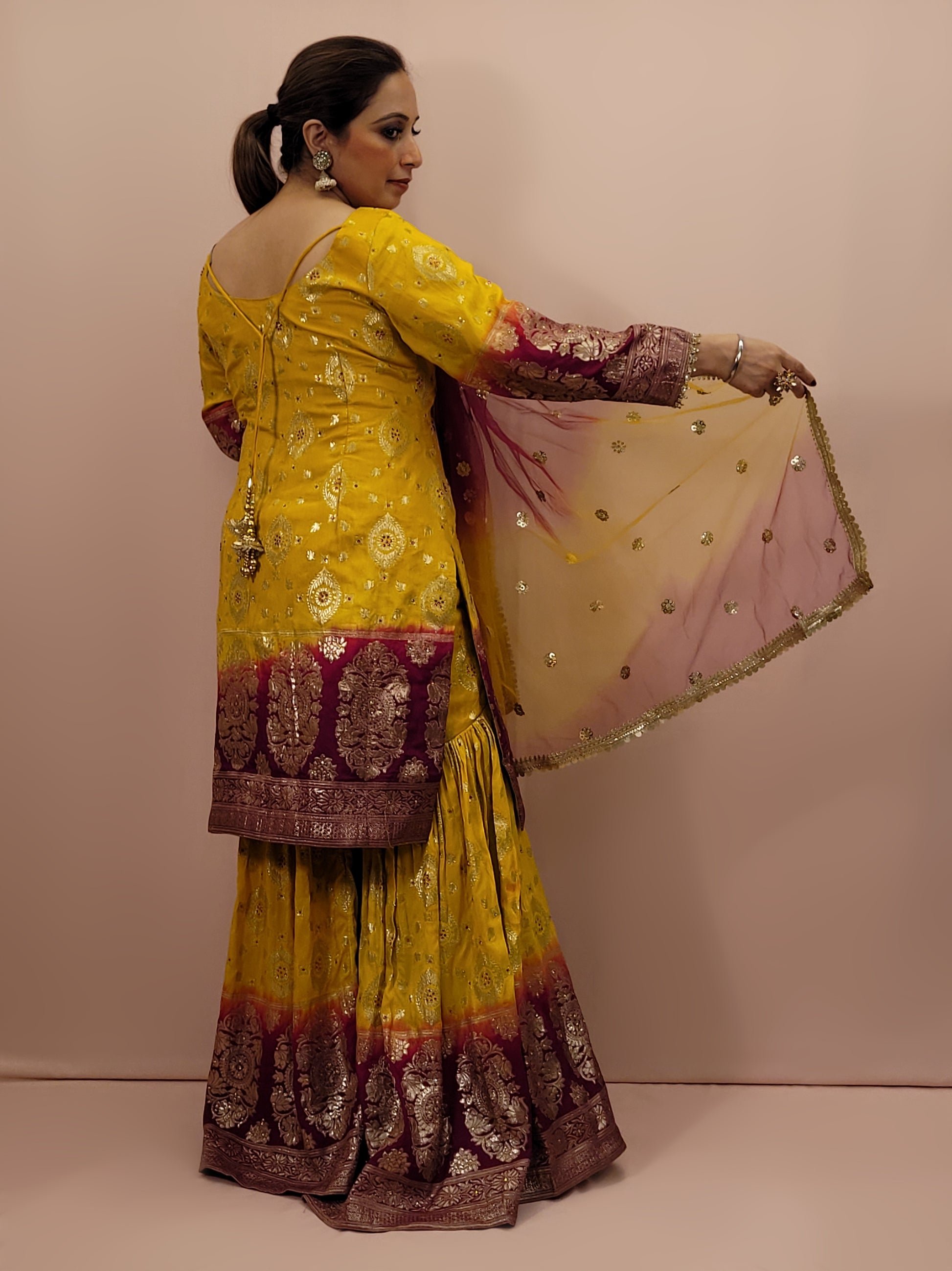 Step into the world of timeless elegance with this stunning Banarasi mustard yellow and maroon sharara suit. This exquisite ensemble is a perfect blend of traditional craftsmanship and contemporary design, making it an ideal choice for weddings, festivals, and special occasions.