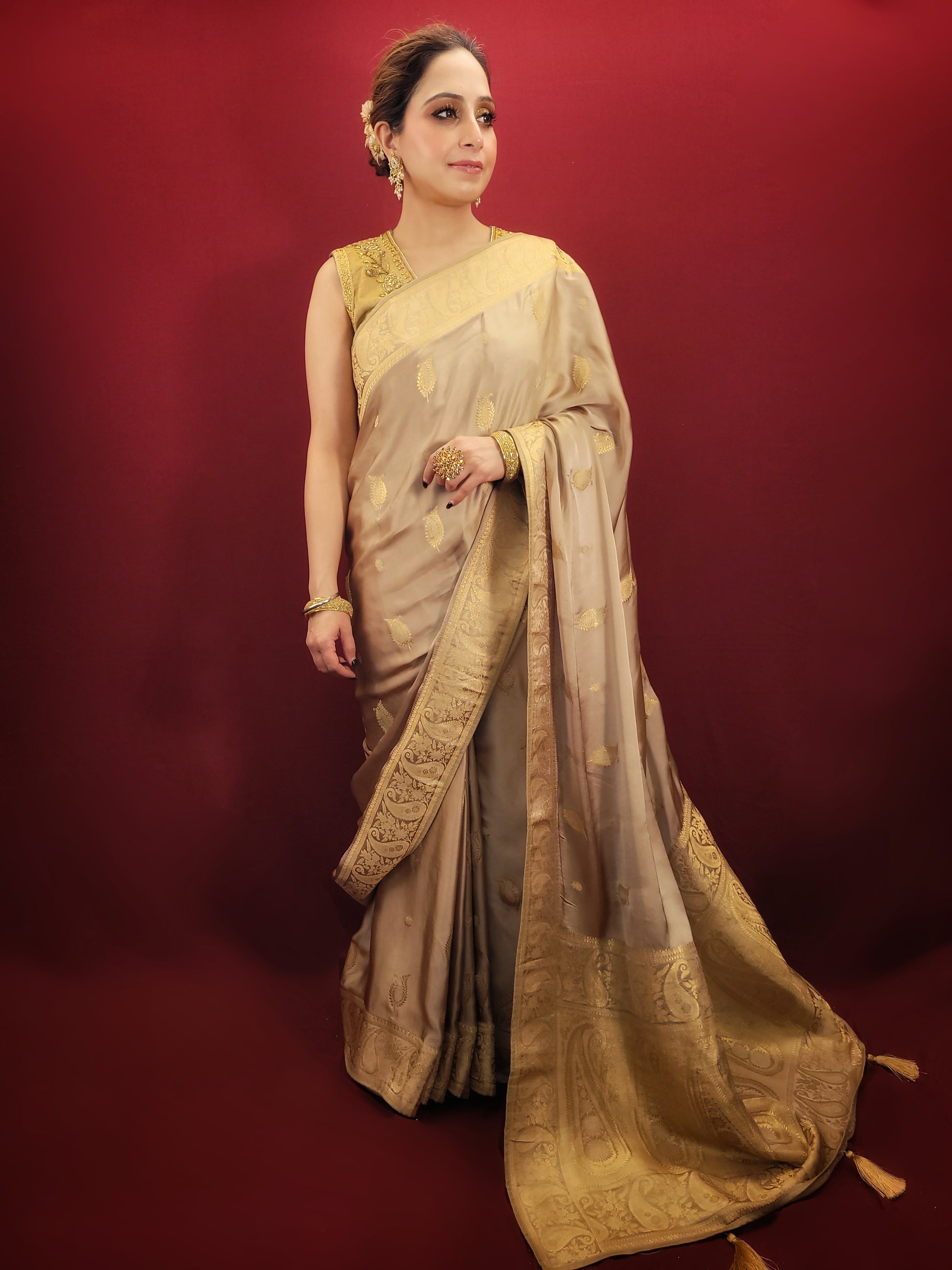 A beautiful saree in beige golden hue, crafted from satin silk with banarsi woven pattern, radiates timeless elegance, perfect for any party wear ocassion.