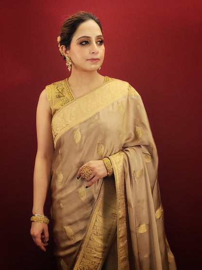 A beautiful saree in beige golden hue, crafted from satin silk with banarsi woven pattern, radiates timeless elegance, perfect for any party wear ocassion.