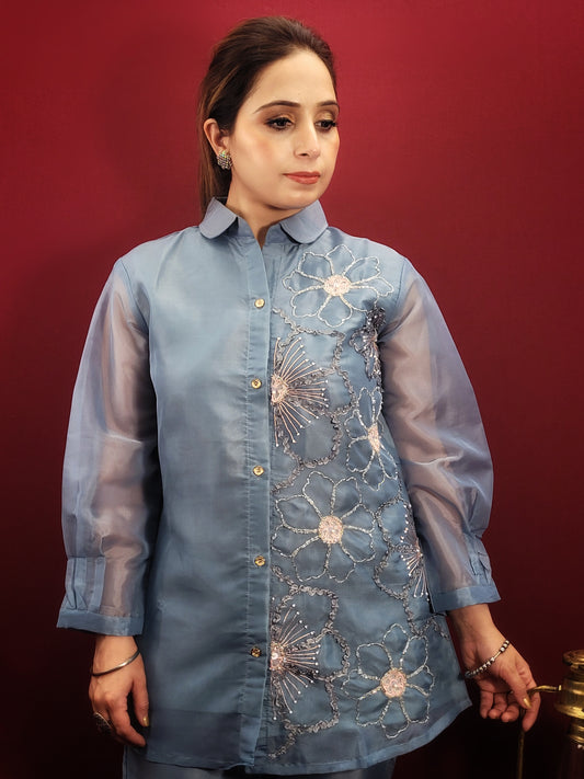 This elegant co-ord set is perfect for various occasions. The collared shirt-style top features intricate resham embroidery, glass beads, and sequins, adding a touch of glamour. The matching pants complete the ensemble, making it suitable for office parties, get-togethers, kitty parties, and light celebrations.